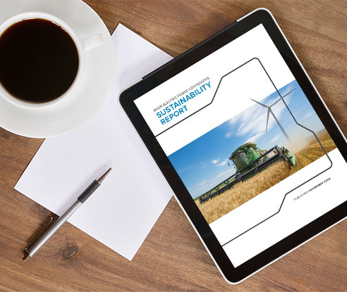 Desk with cup of coffee and tablet showing the Sustainability Report cover